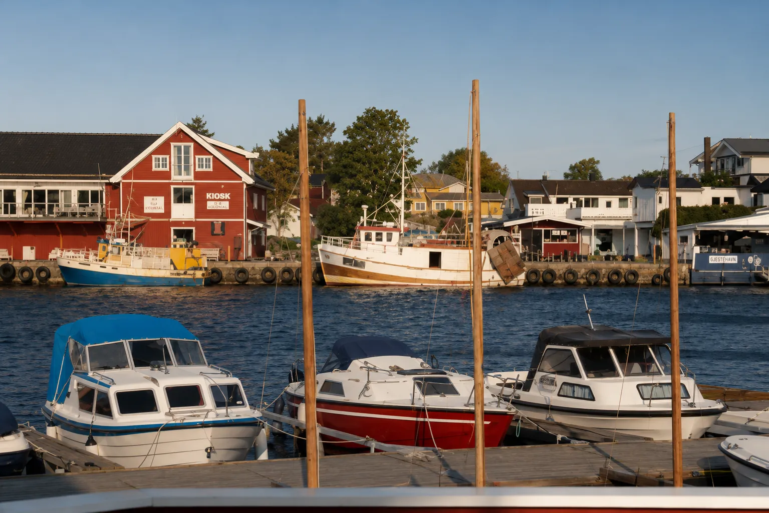 Sandesund havn på Hvasser i ettermiddagslys — fritidsbåter, sjøboder og kysthus